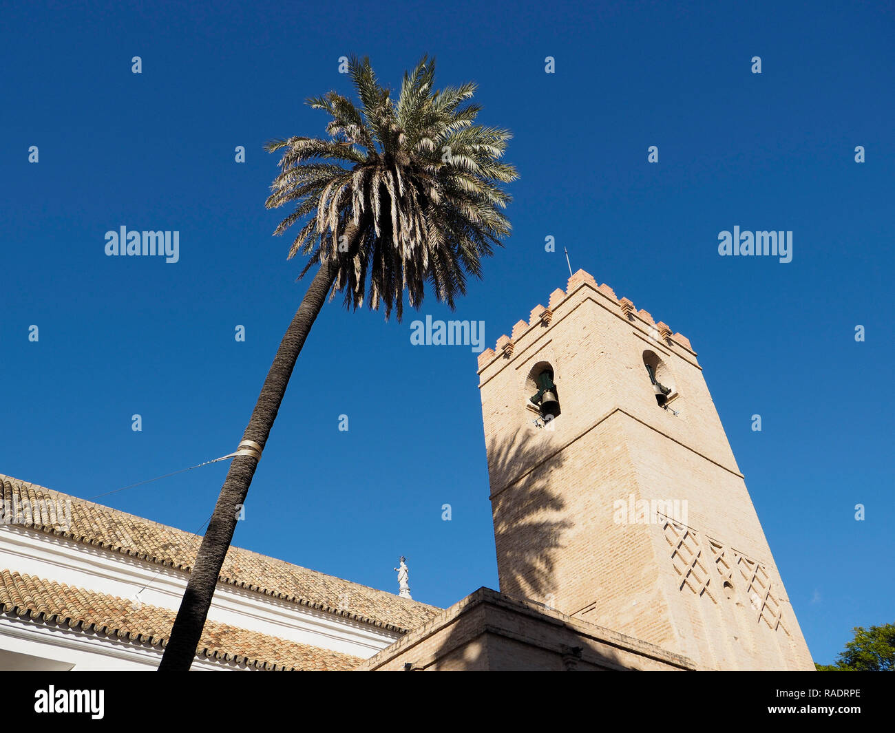 Sevilla, Andalusien, Spanien, kleine Kirche im Zentrum der Stadt mit Palme gegen den blauen Himmel Stockfoto