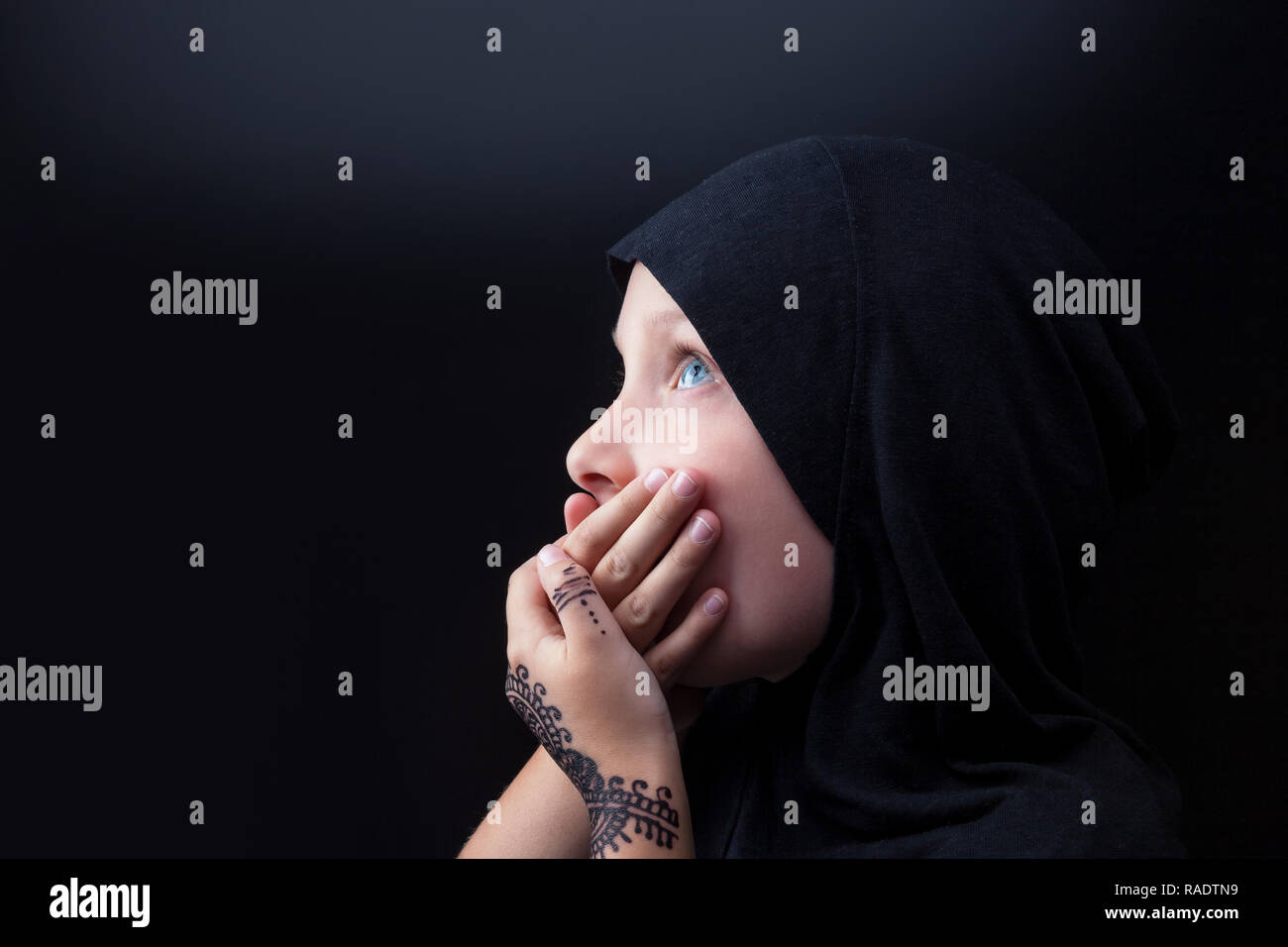 Kleines Mädchen mit blauen Augen in den moslemischen Hijab für Mund. Rassismus und Religion problem. Stockfoto