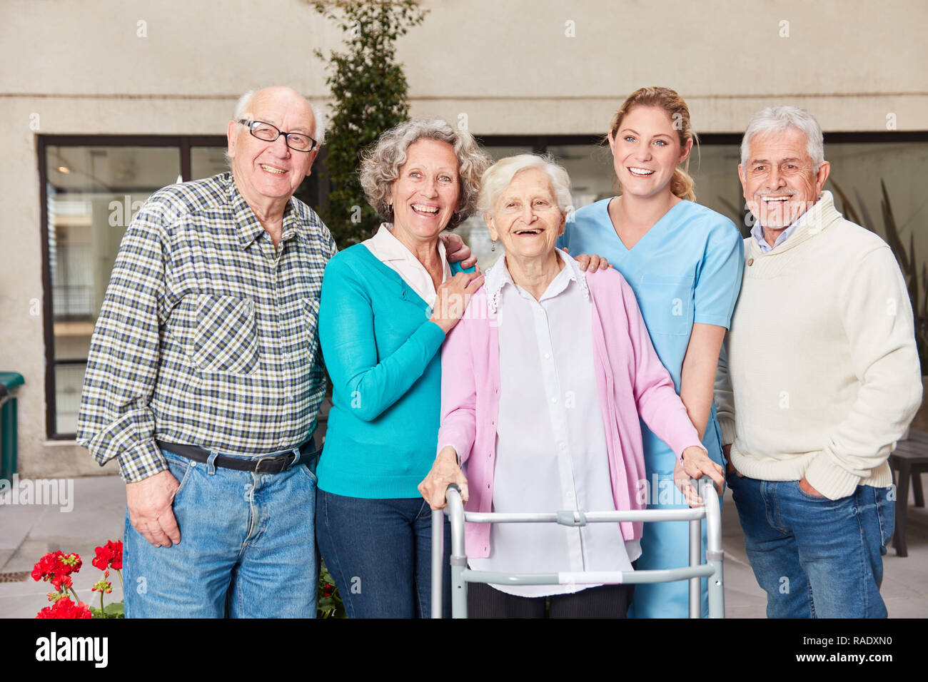 Gruppe von Senioren als Freunde lachen gerne mit altenpflegerin im Ruhestand home Stockfoto