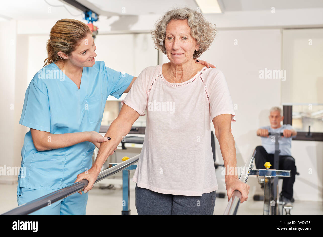 Ältere Frau in Ausbildung zusammen mit Physiotherapeut im rehab Stockfoto