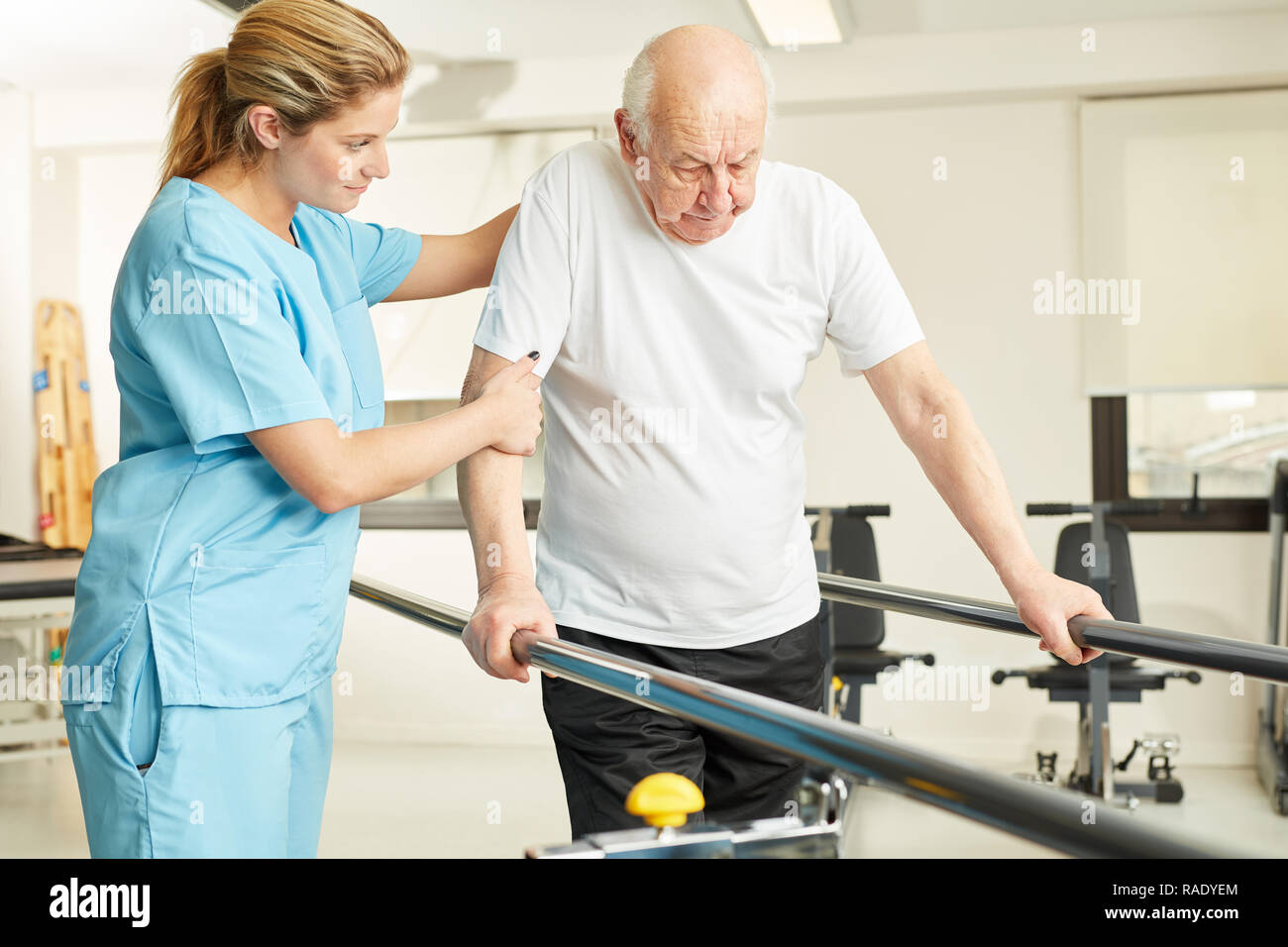 Physiotherapeut hilft älteren Menschen mit Handicap während der Ausführung im rehab Stockfoto