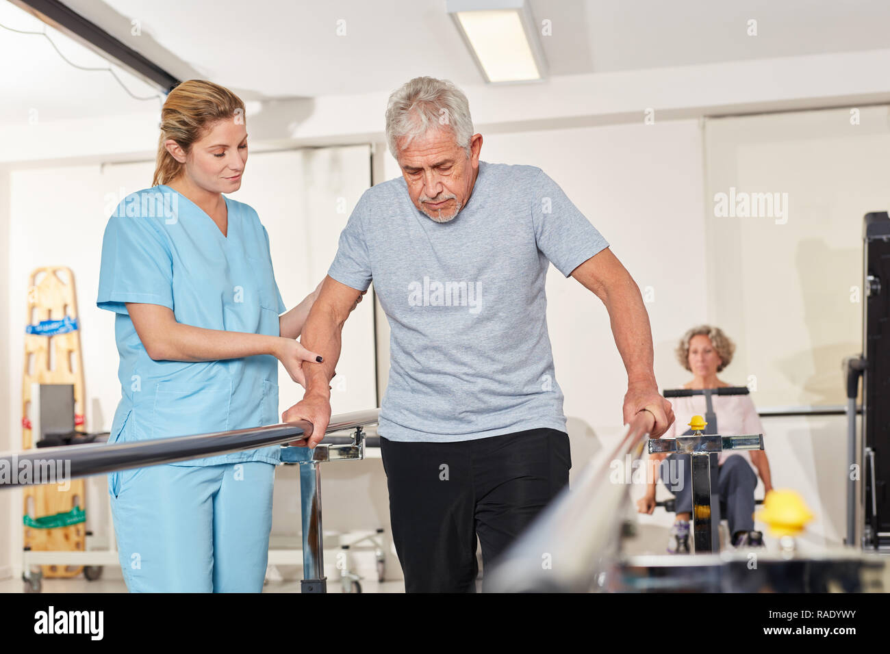 Physiotherapeut hilft älteren Menschen mit rehab auf dem Laufband Stockfoto