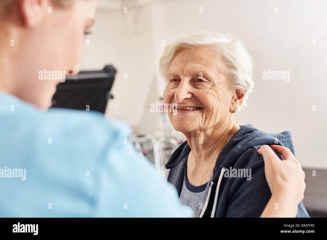 Therapeut motiviert die kranken älteren Frau als rehab Patienten in der Physiotherapie Stockfoto