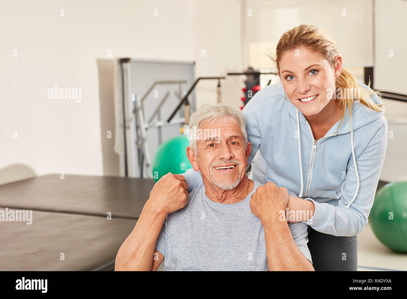 Ältere Menschen und Physiotherapeut in der REHA-Klinik im Fitnesscenter Stockfoto