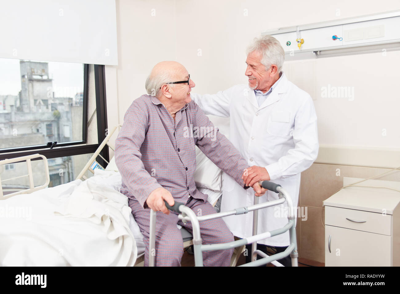 Arzt und älterer Mann mit Walker Behandlung in der Reha Klinik besprechen Stockfoto