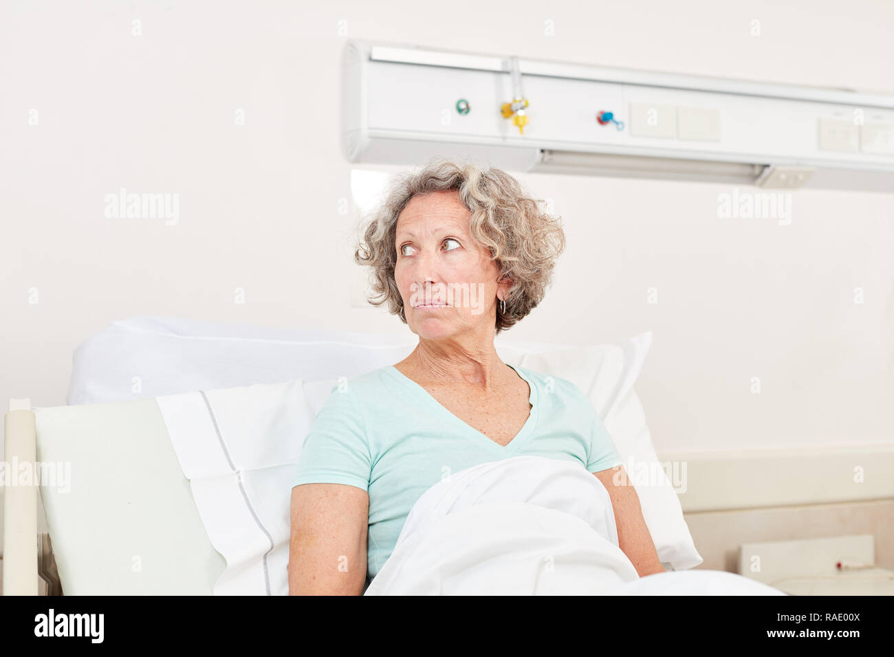 Ältere Frau sorgt sich als Patient in Bett im Krankenhaus Stockfoto