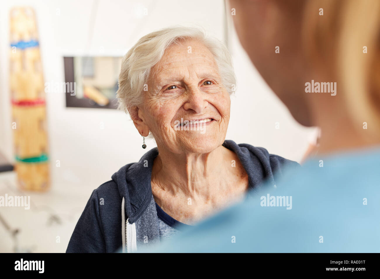 Zufrieden ältere Frau im rehab zusammen mit Physiotherapeuten Stockfoto