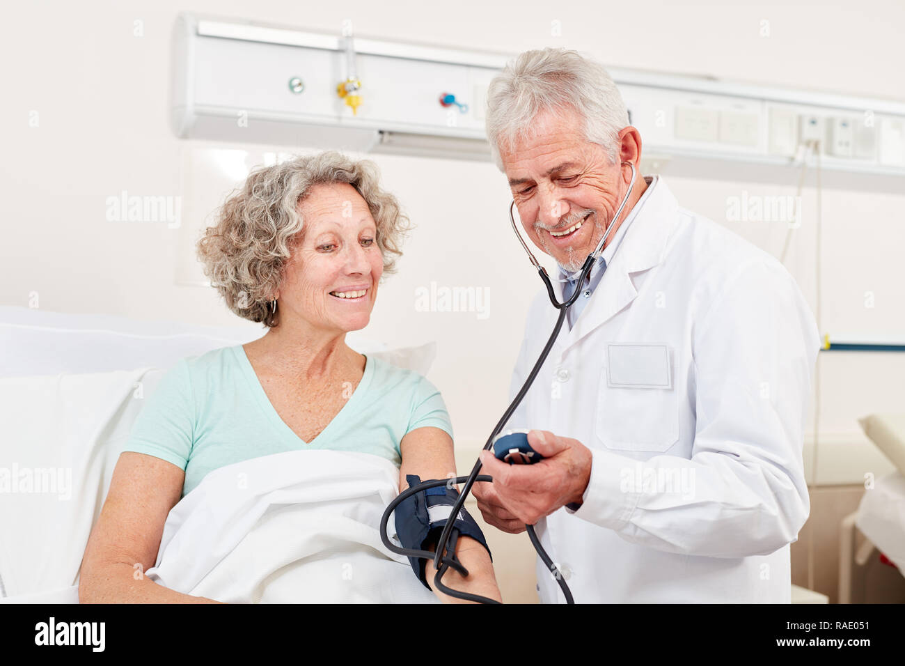 Erfahrenen Arzt prüft den Blutdruck eines Patienten im Krankenhaus Stockfoto