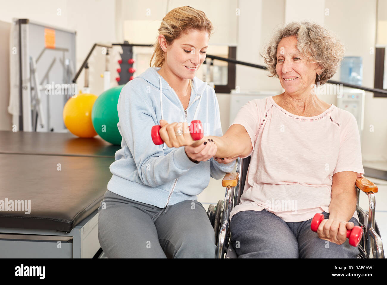 Physiotherapeut Hilfen ältere Frau mit Handicap am rehab Hantel Training Stockfoto