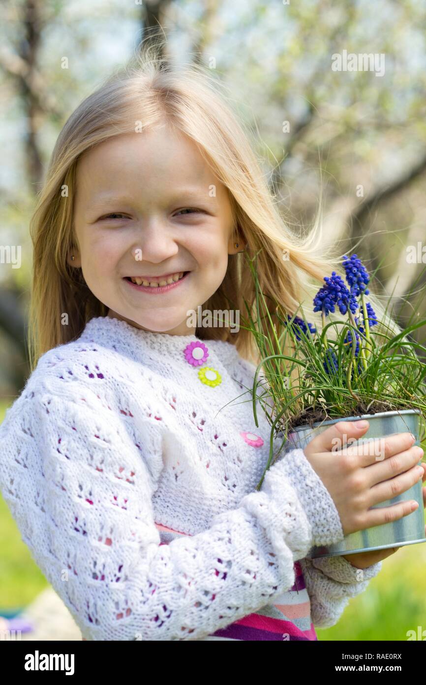 Lächelnde Mädchen mit Blumen Hyazinthen im Topf Stockfoto