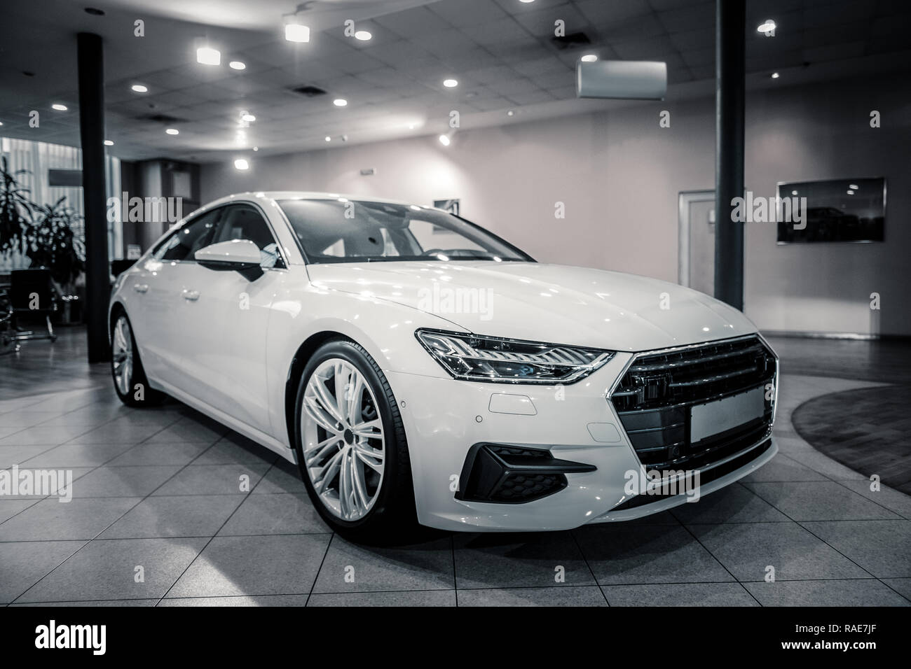 Komfortable weißes Auto scheint beim Stehen in der Autohaus Stockfoto