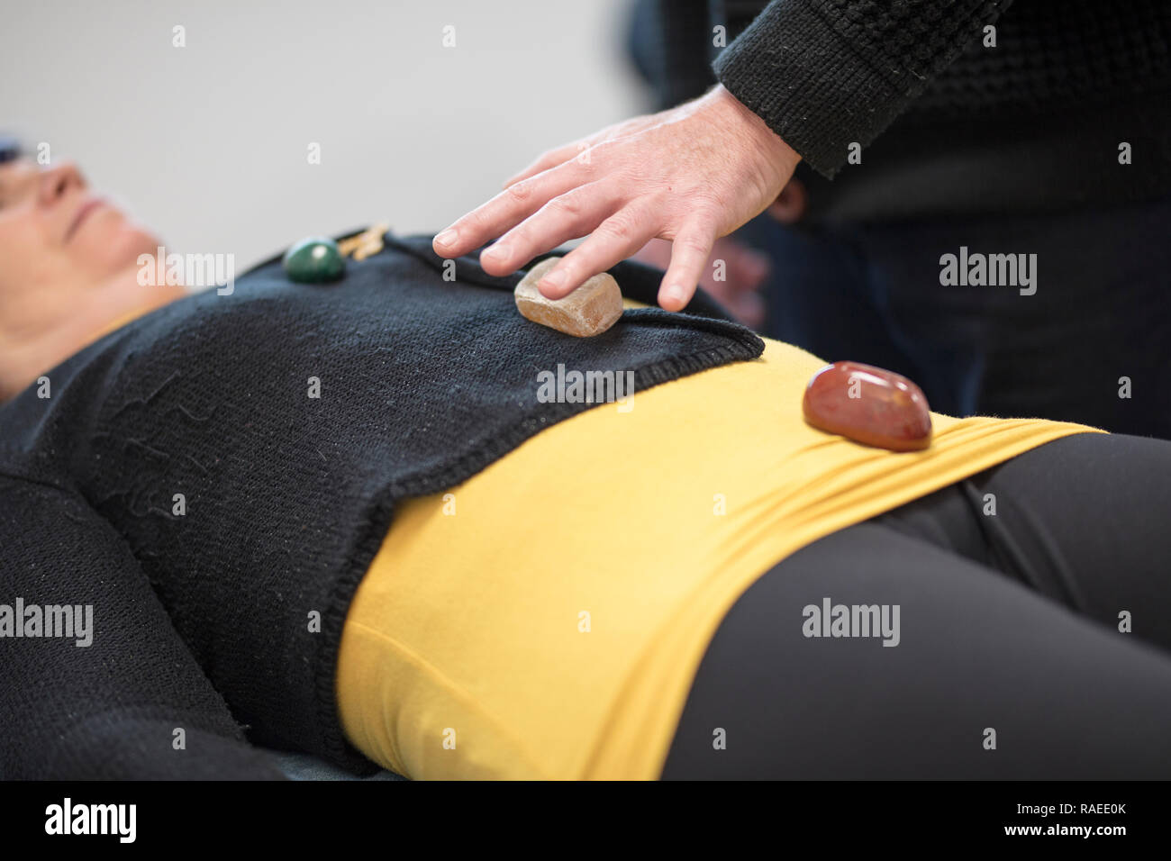 Hypnotiseur. Therapeutische Magnetismus, Heilung mit Steinen. Festlegung der Hände über den Körper eines Patienten, eine Frau, für die Regelenergie. Stockfoto