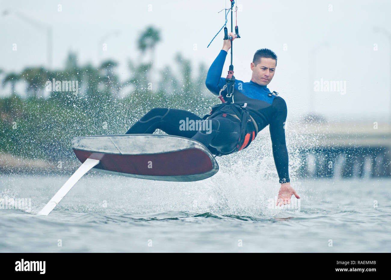 Männliche Kitesurfer Reiten Tragflügelboot und mit großer Geschicklichkeit und Sportlichkeit Stockfoto