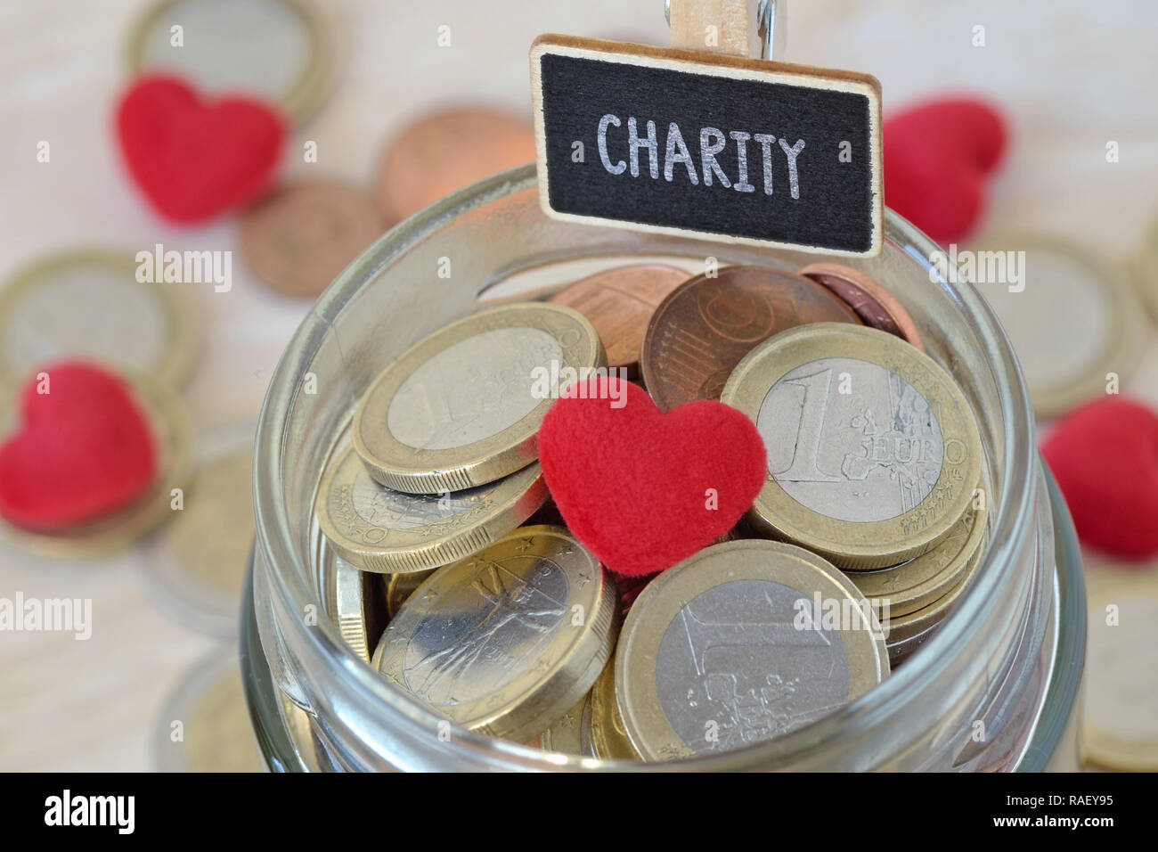 Euro Münzen und Herzen aus Glas geld Glas mit Charity Label - Nächstenliebe Konzept Stockfoto