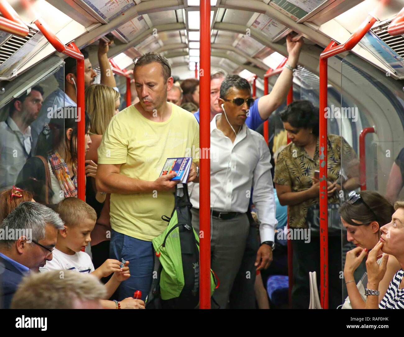 Heraus und über die Passagiere erleben heißen Temperaturen in der Londoner U-Bahn, Central Line. Bild von: NIGEL HOWARD © e-Mail: nigelhowardmedia@gm Stockfoto