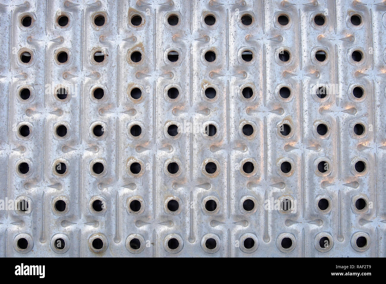 Eine Reihe von Bohrungen, die in Zeilen und Spalten, die auf einer metallischen Oberfläche Stockfoto