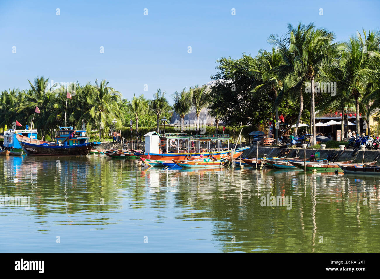 Traditionelle Boote auf dem Thu Bon Fluss gesäumt von Palmen in der Altstadt der historischen Stadt. Hoi An, Quang Nam, Vietnam, Asien Stockfoto