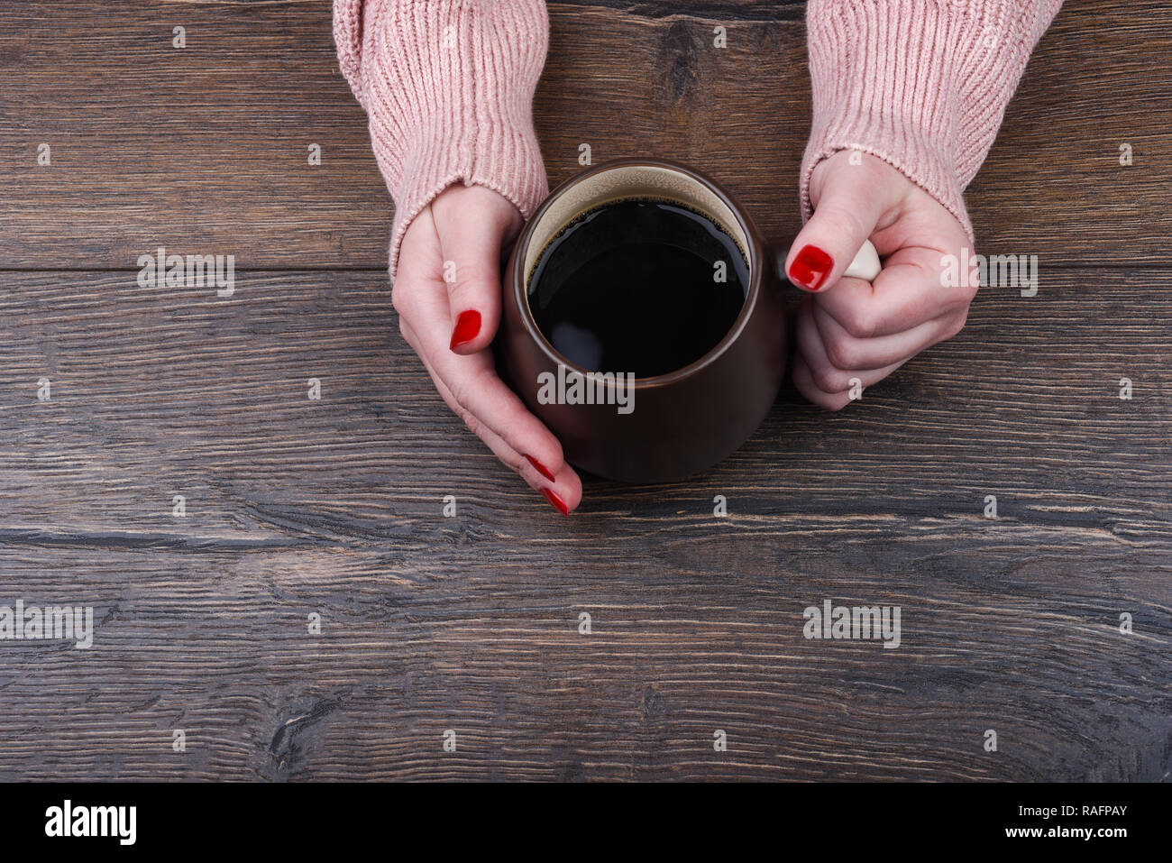Das Mädchen hält den Griff eines großen Becher Kaffee Stockfoto