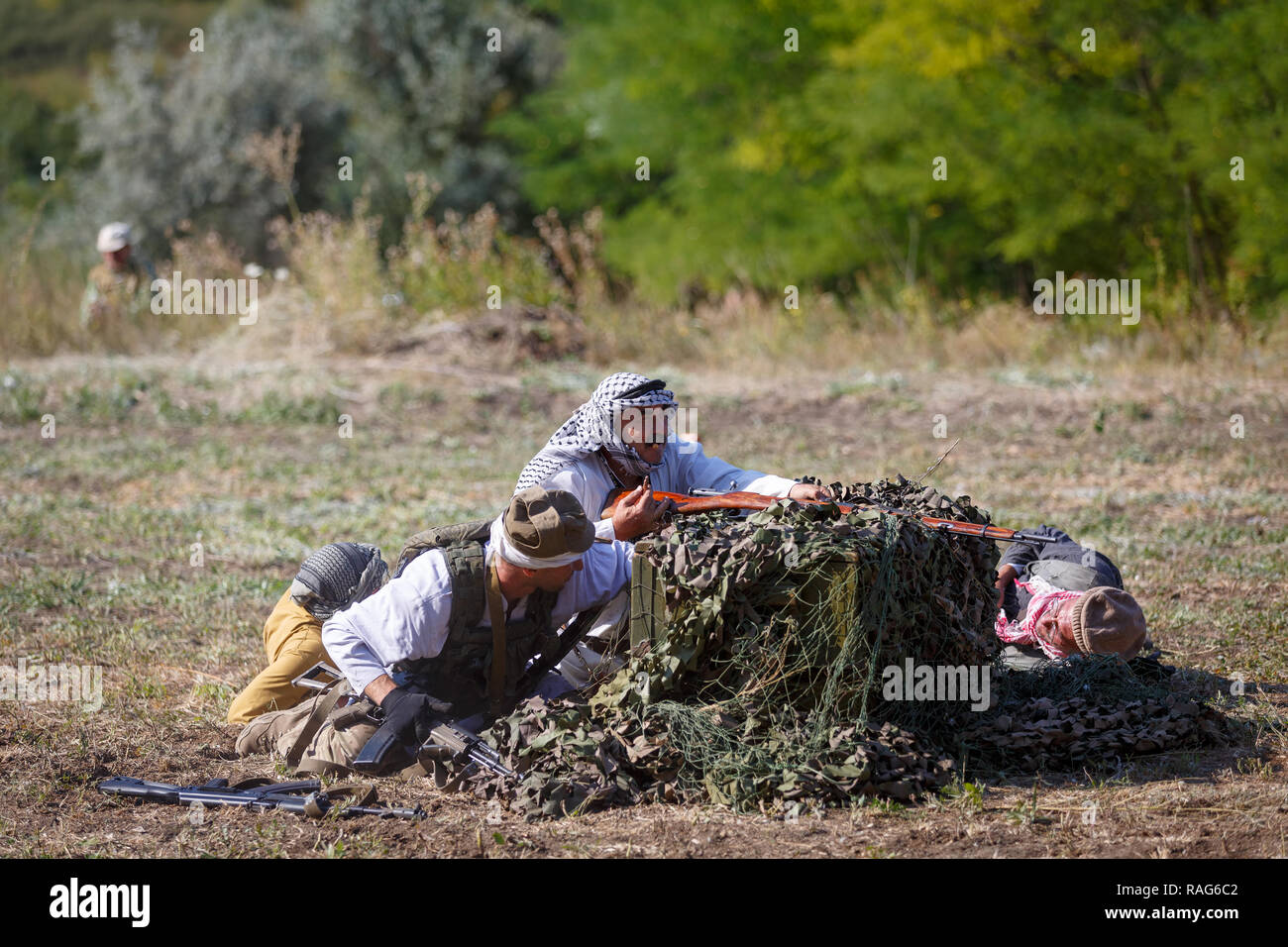 Historische Festival Sambek Höhen. Mudschahedin sitzen hinter grünen Kisten mit Waffen Stockfoto