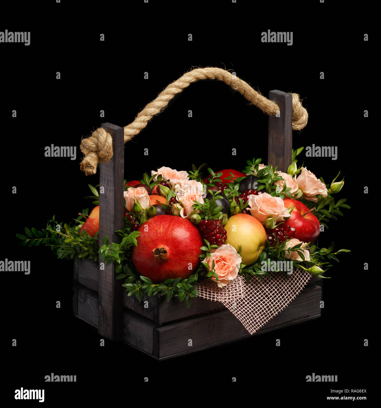 Erstaunlich genießbare Jahrestag Geschenk in Form von einer Holzkiste mit Rosen und verschiedene Früchte auf einem schwarzen Hintergrund gefüllt Stockfoto