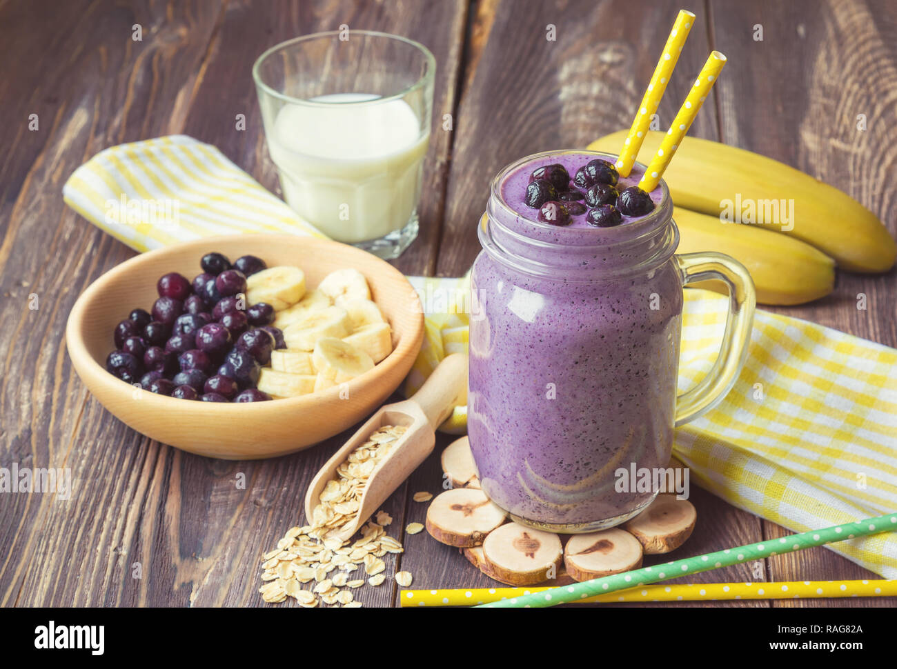 Blueberry Smoothie mit Banane und Haferflocken in Glas auf rustikalen Holzmöbeln Hintergrund Stockfoto