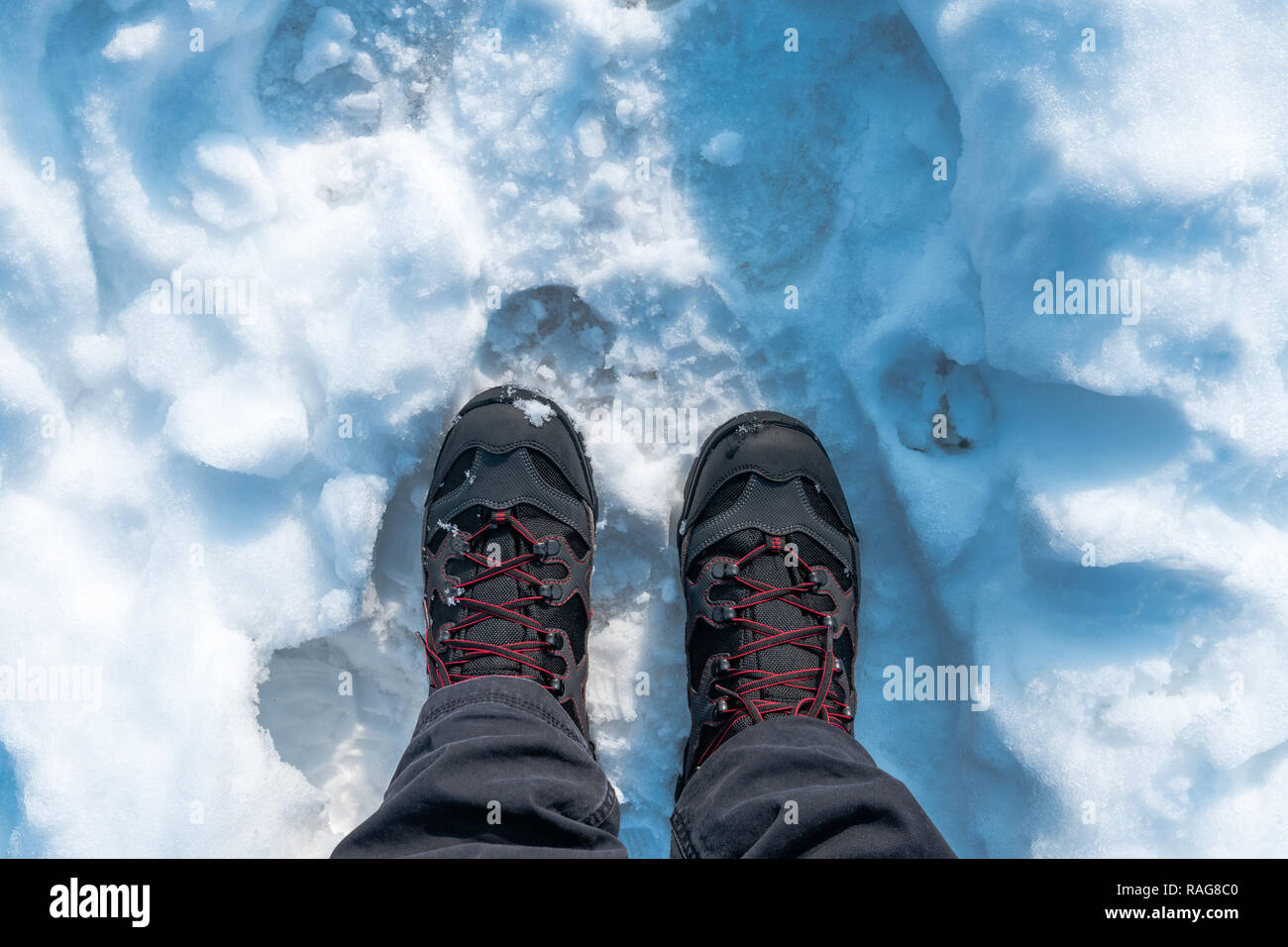 Männliche Füße in Stiefeln stehen in reiner Winter Schnee, Ansicht von oben Stockfoto