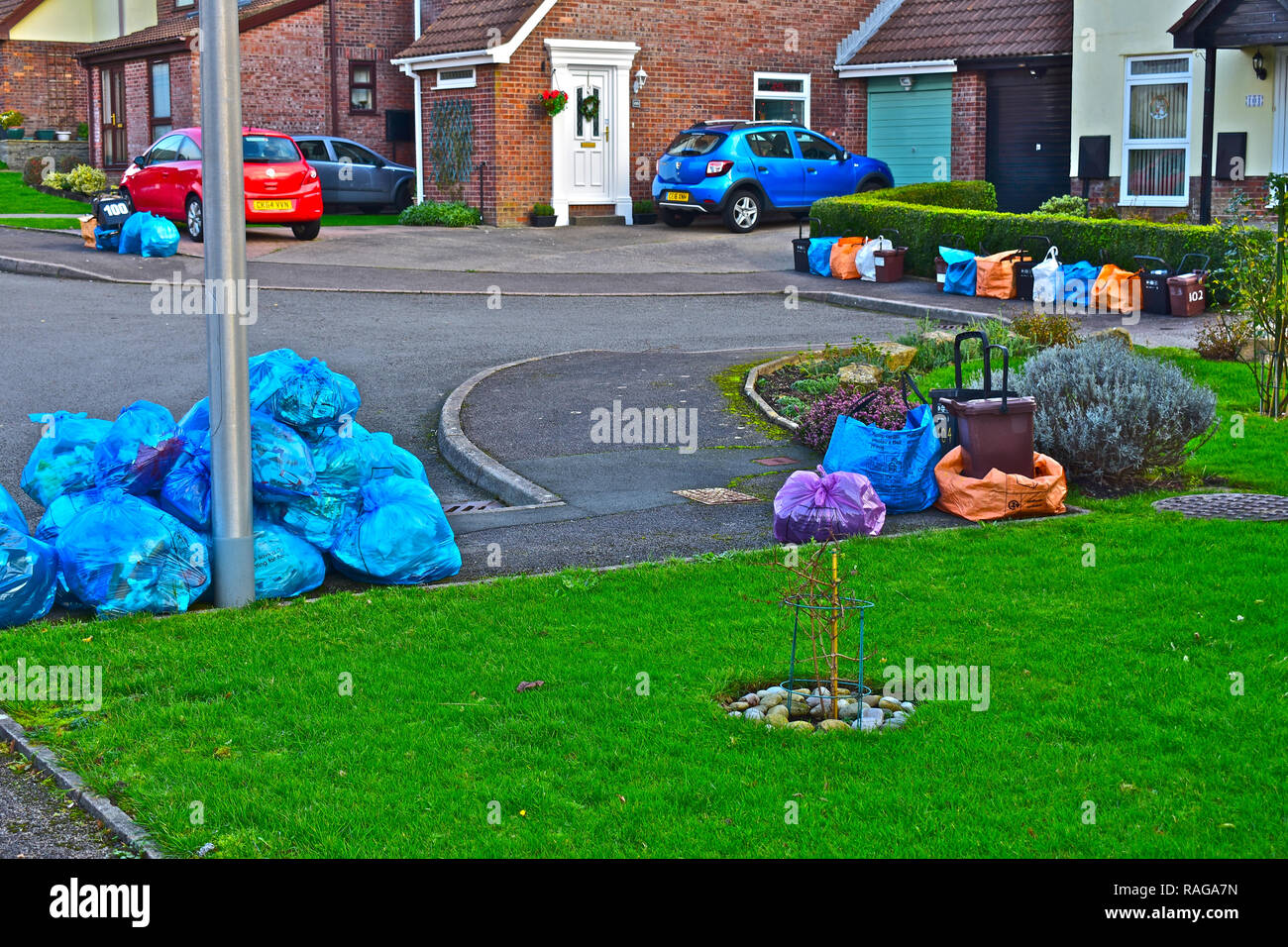 Recycling Taschen, Behälter und Müll auf der Straße aufgetürmt Warten auf Abholung im modernen Viertel von Suburban homes. Stockfoto