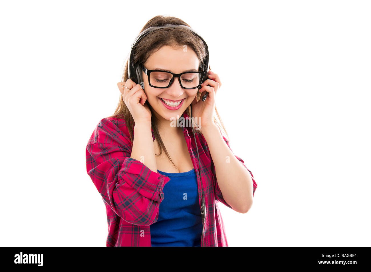 Glückliche junge Teenager im legeren Outfit und Brille mit Kopfhörer und das Hören von Musik auf weißem Hintergrund Stockfoto