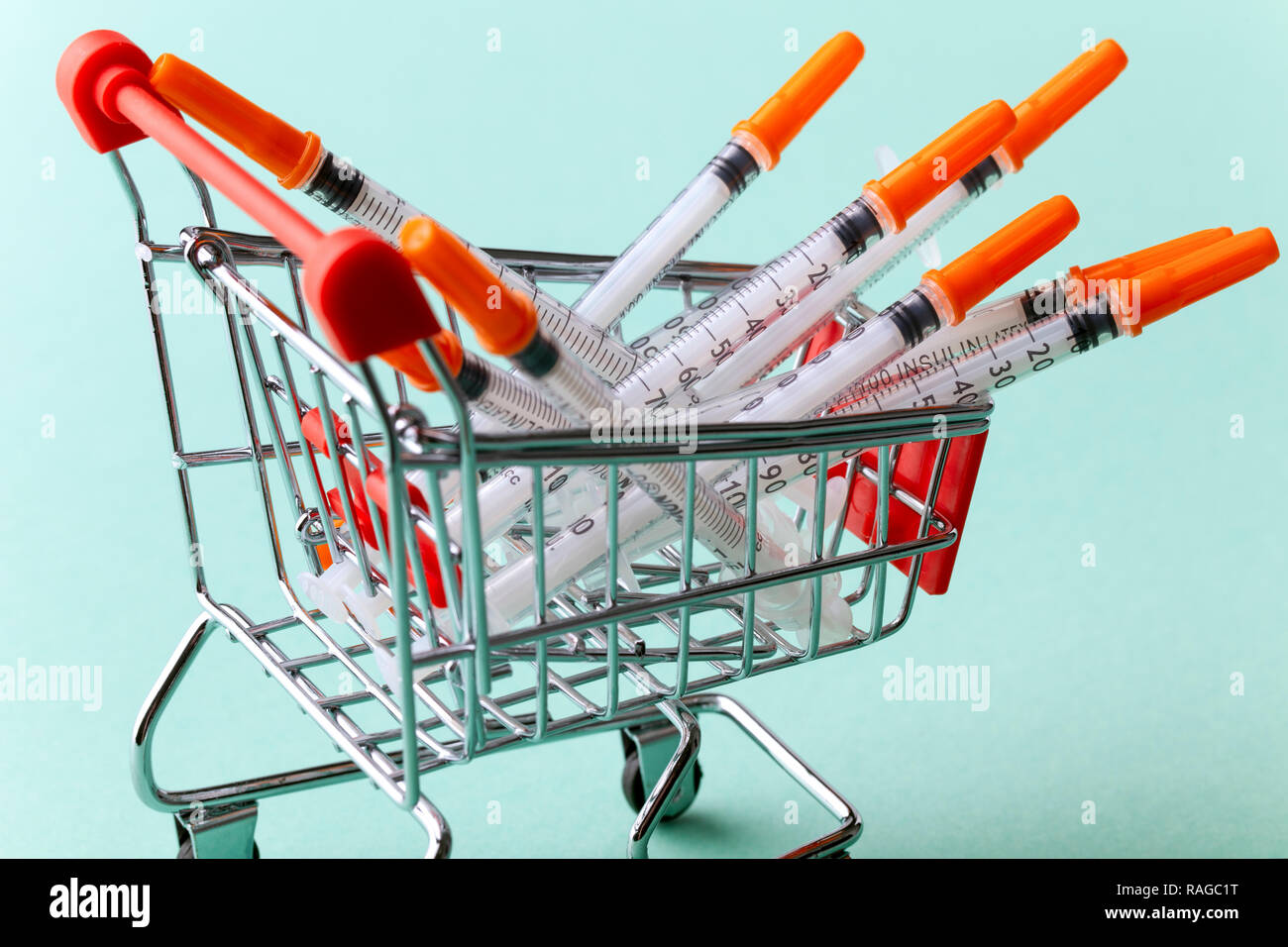 Insulinspritzen in Rot Warenkorb Trolley auf blauem Hintergrund Stockfoto