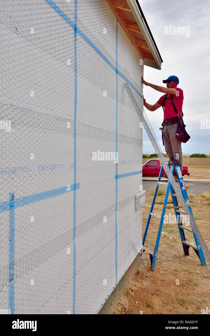 Haus im Bau mit builder Power nailer zu installieren Armierungsgeflecht für Stuck Finish über Isolierplatte Stockfoto