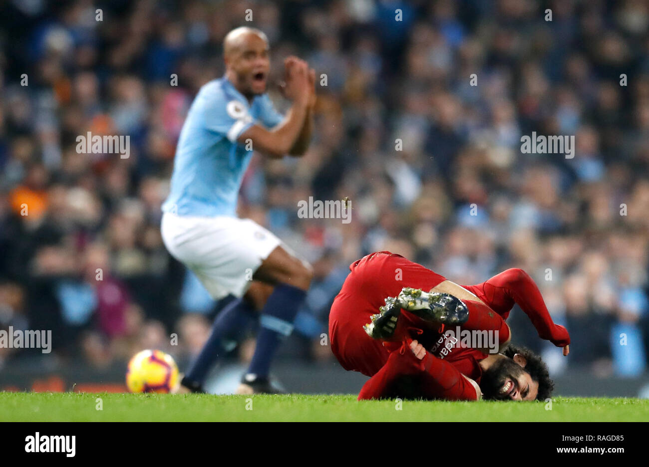 Von Manchester City Vincent Kompany reagiert, nachdem ein Angriff auf Liverpools Mohamed Salah (rechts), aus der sich eine gelbe Karte, während der Premier League Match an der Etihad Stadium, Manchester. Stockfoto