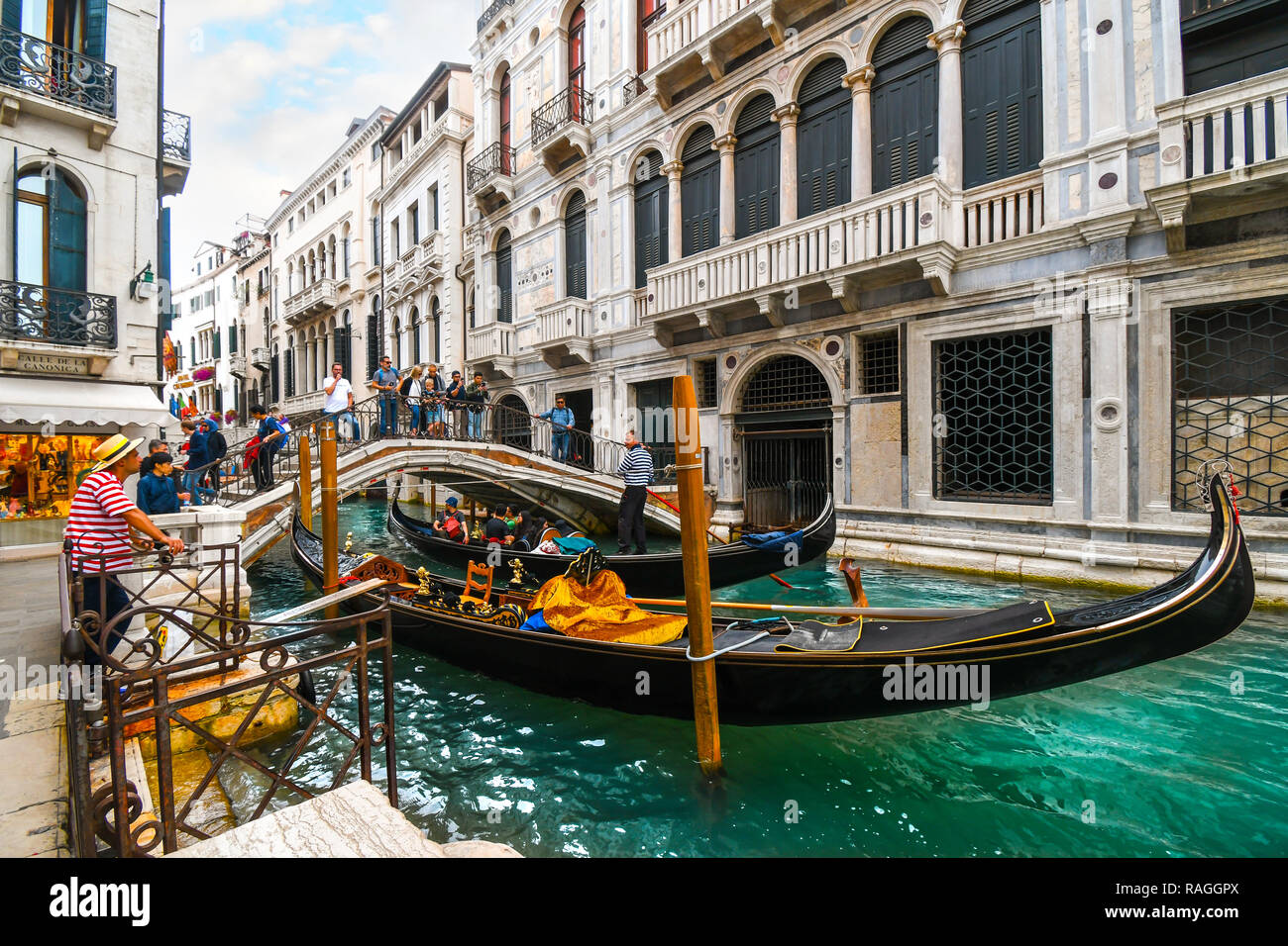 Einem langen Abschnitt des Kanals in der Calle de La Canonica als Touristen, überqueren Sie die Brücke über die Gondel und ein gondoliere wartet auf Kunden in Venedig, Italien Stockfoto
