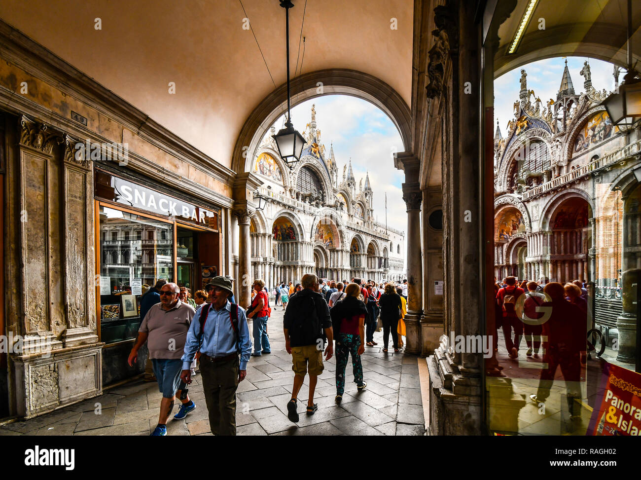 Touristen fahren Sie durch den Tunnel unter dem Turm und auf dem Markusplatz und der Basilika in Venedig, Italien Stockfoto