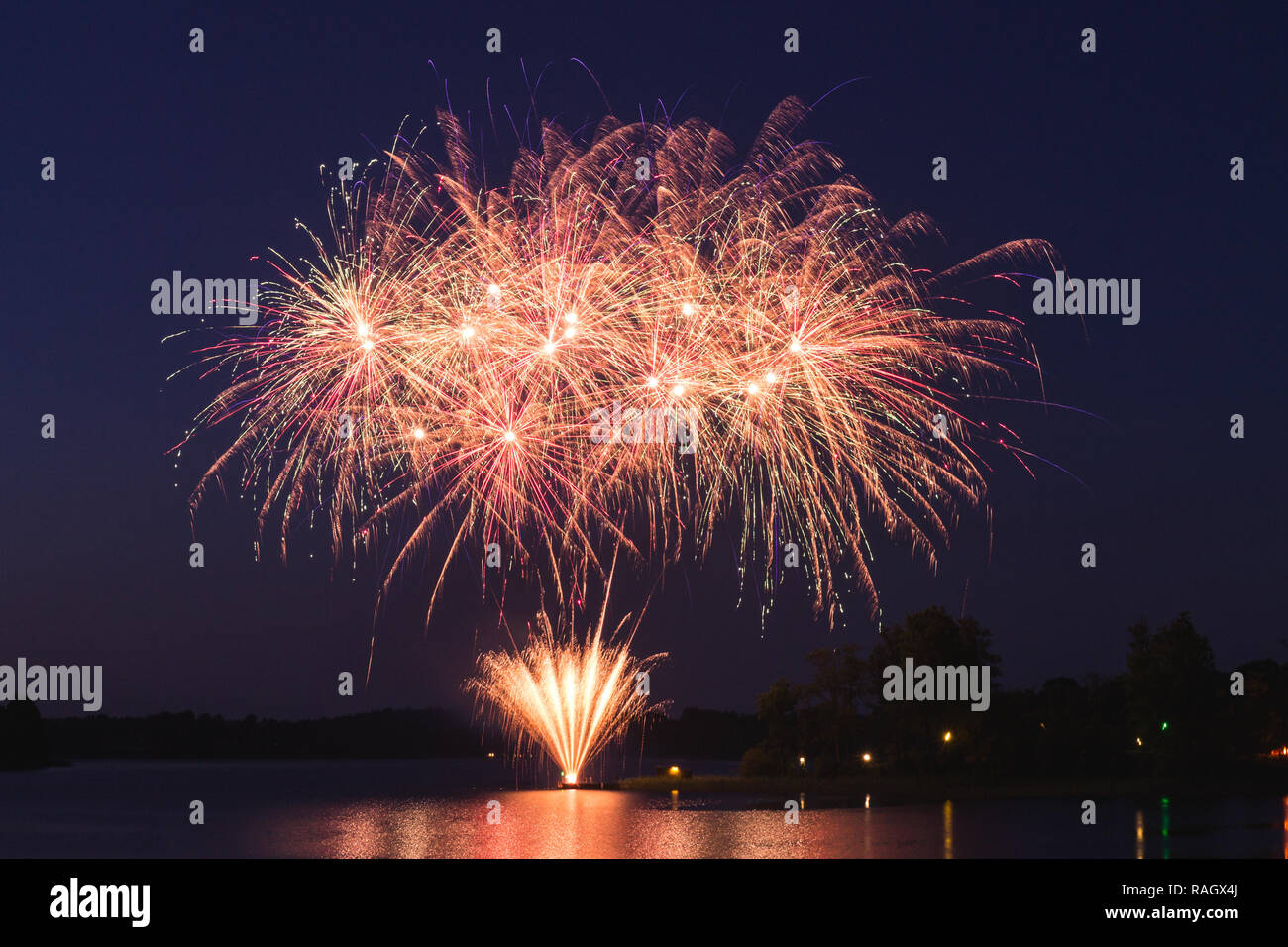 Riesige rosa und orange Feuerwerk in der Nacht über den See duri Stockfoto