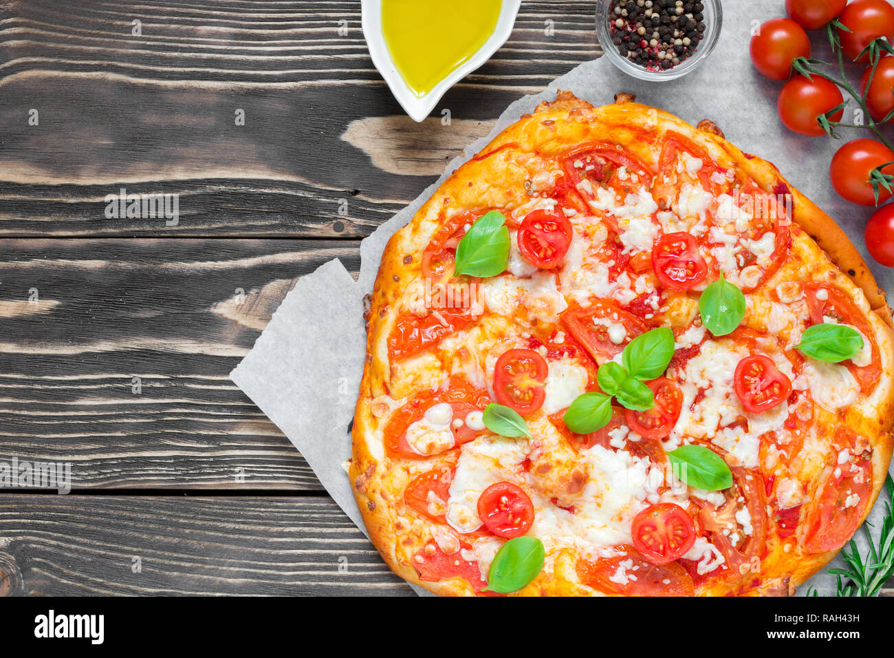Pizza Margherita mit Tomaten, Basilikum und Mozzarella über rustikal Hintergrund. Ansicht von oben mit der Kopie Raum Stockfoto