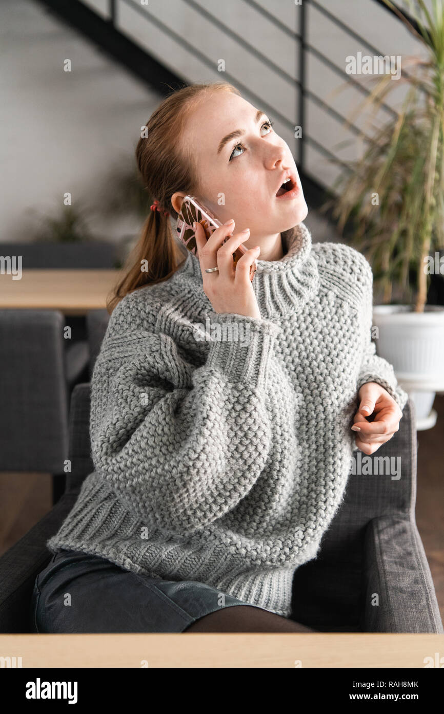 Porträt einer schönen Teenager entspannende und über ein Mobiltelefon, ein Gespräch mit Freunden zu haben, lächelnd und Flirten Stockfoto