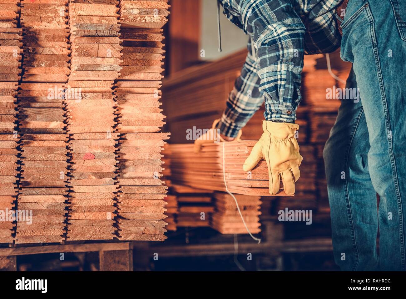 Stapel von Planken und kaukasische Auftragnehmer. Auswahl der richtigen Holzplanken. Stockfoto