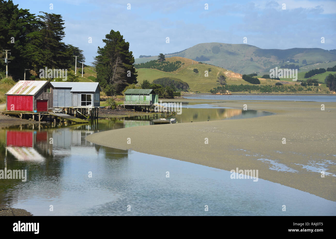 Einer der vielen Lagunen auf der Otago Halbinsel die charmante Boot Häuser an einem sonnigen Tag im Sommer. Stockfoto