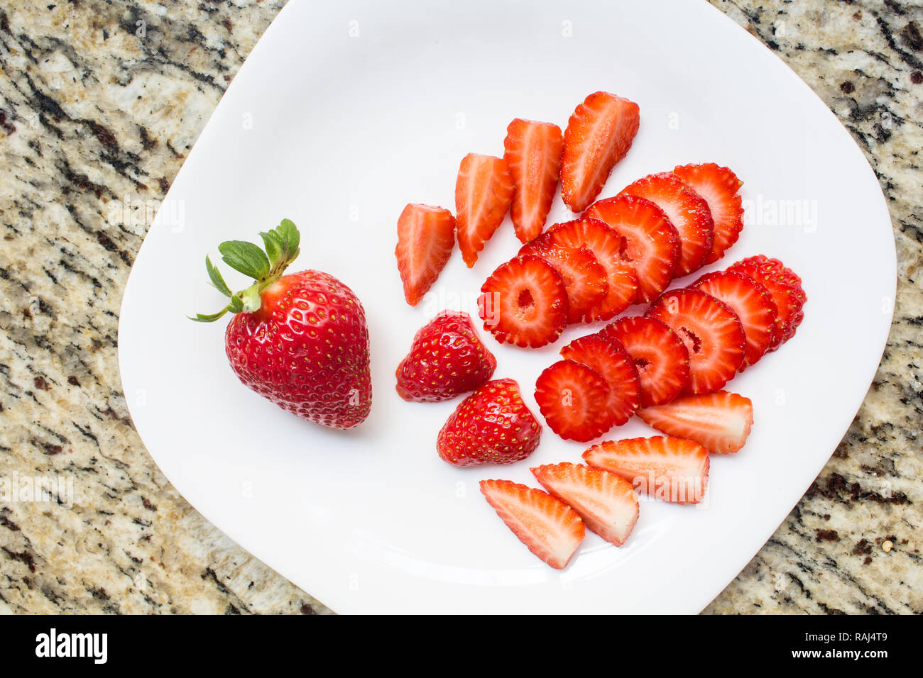 Frische Erdbeeren Schnitte auf weissen Teller, Obst lecker. Dessert gesund und reich an Vitaminen. Stockfoto