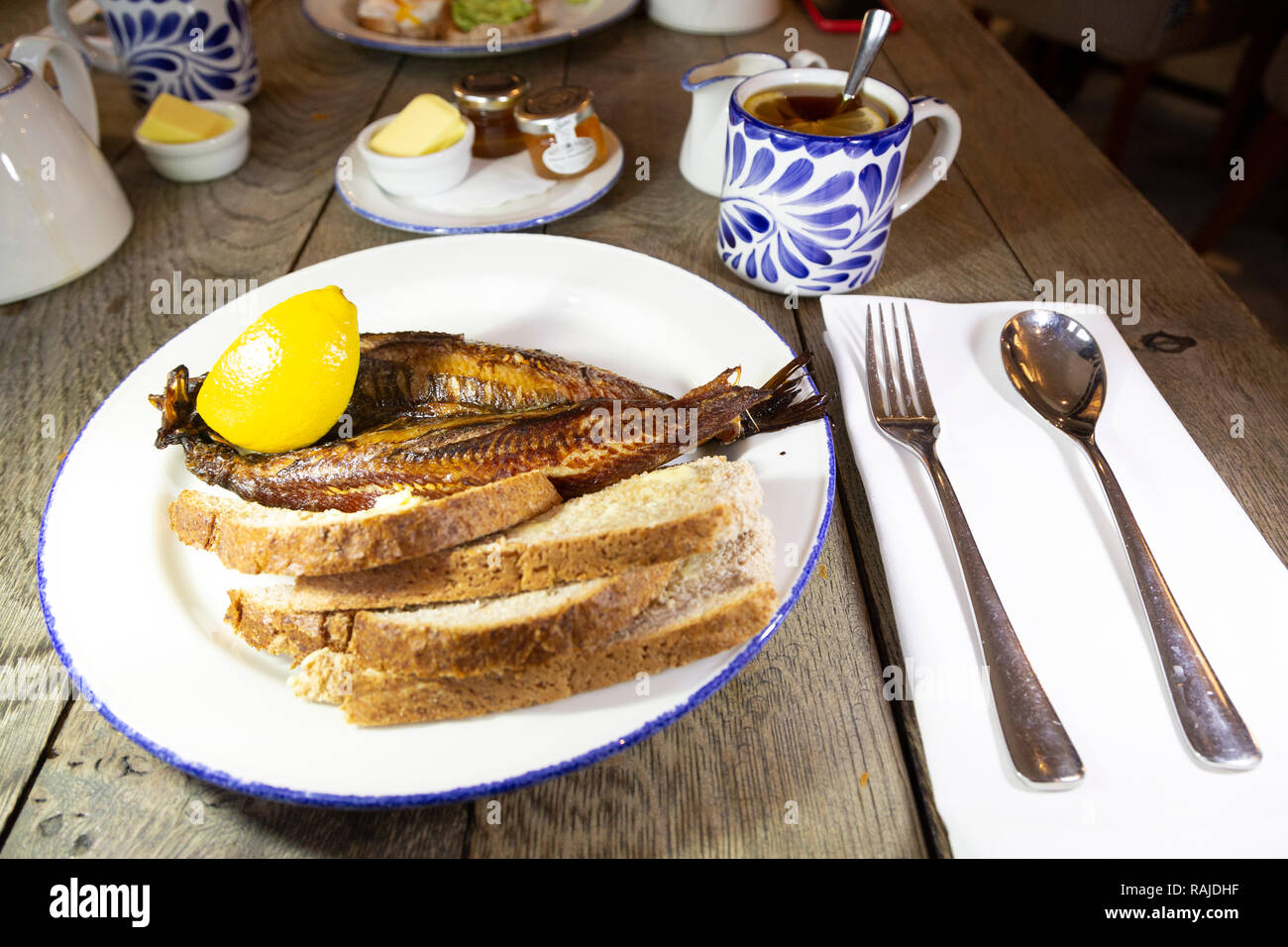 Craster kipper serviert mit Toast zum Frühstück in Northumberland, England. Die northumbrian Delikatesse ist mit Earl Grey Tee serviert. Stockfoto