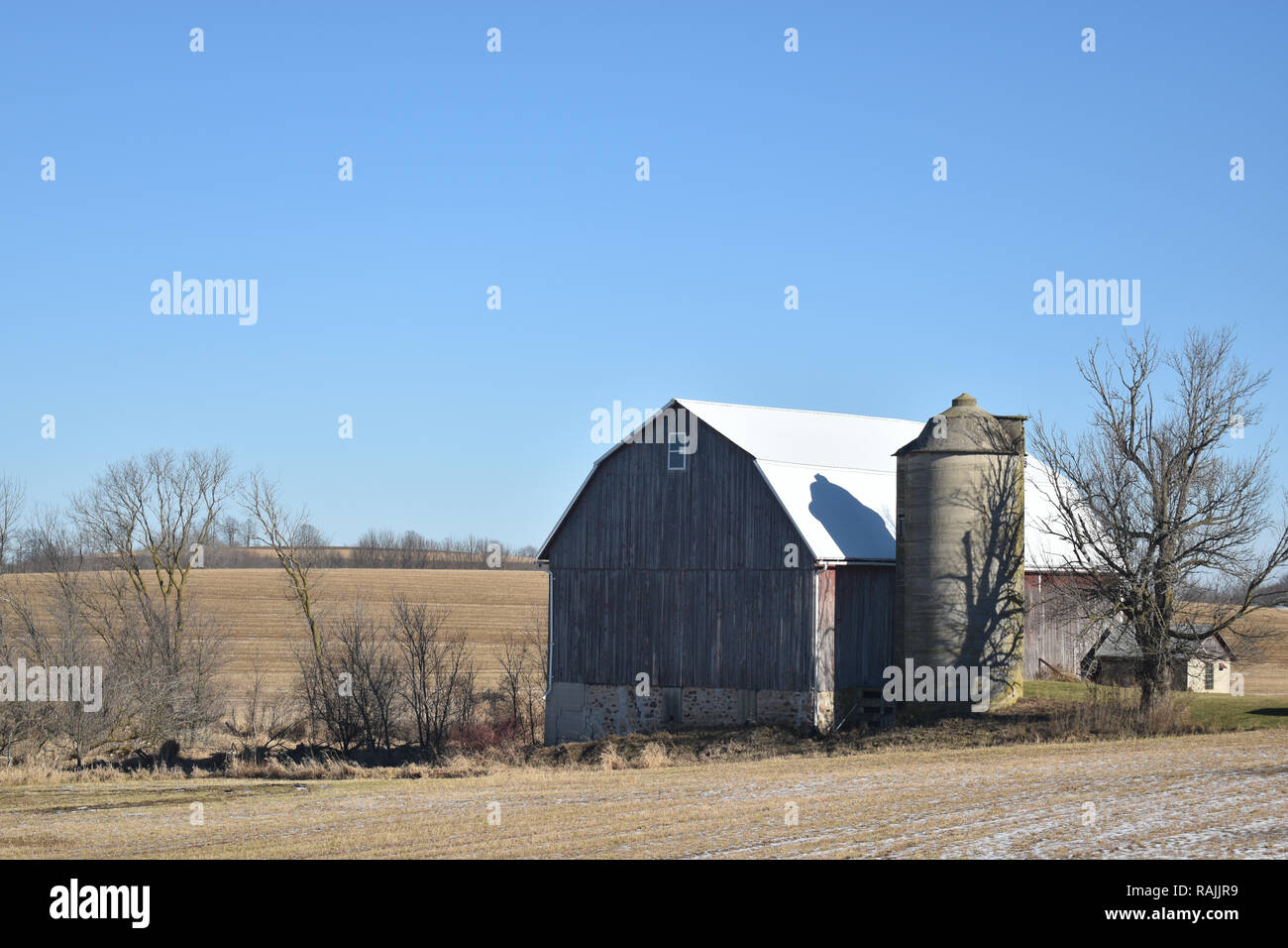 Vintage traditionelle Scheune und Silo auf einem Bauernhof im Spätherbst an einem sonnigen Tag Stockfoto