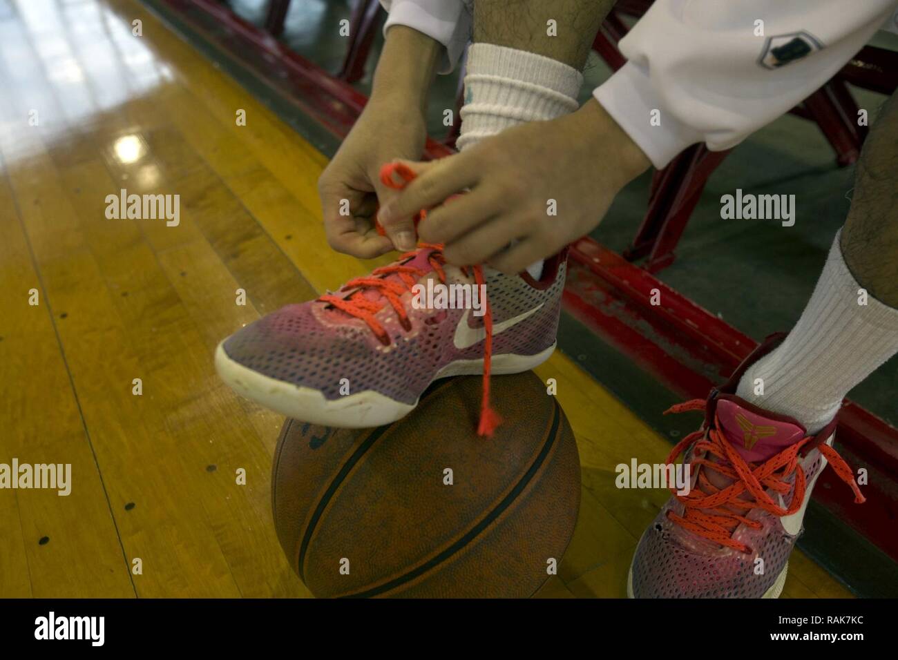 Ein Kursteilnehmerathlet Riegel seinen Schuh vor dem 11. jährlichen Freundschaft Basketball Turnier Feb 4 an Bord Camp Foster, Okinawa, Japan. Das Turnier wurde von dem US-Generalkonsulat, Naha, Okinawa gefördert. High School Mannschaften aus dem Lokalen und militärischen Gemeinschaften auf Okinawa nahmen an dem Turnier, die Teams zusammenzubringen, freundliche Spiele der Basketball zu spielen. Stockfoto