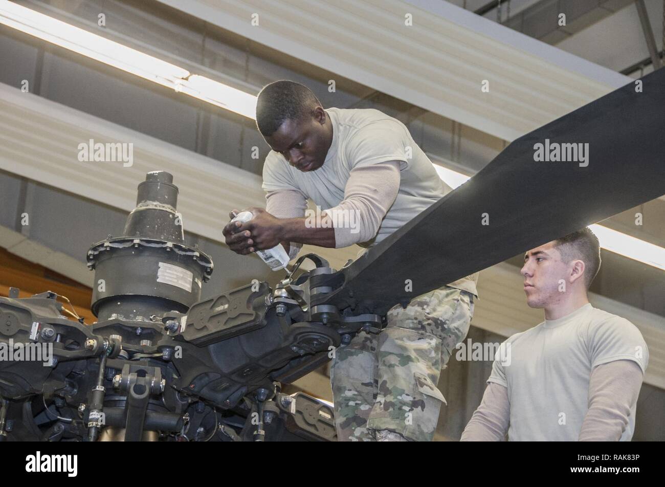 Spc. Ainsworth L. Carridice und SPC. Jose Castaneda mit Delta Unternehmen 1 Bataillon, 3 Aviation Regiment (Attack Reconnaissance) Verhalten phase Instandhaltung für ein AH-64 Apache Helikopter am Katterbach Army Airfield, Deutschland, 10.02.2017. Phase Wartungsinspektionen auftreten, die in regelmäßigen Abständen auf alle Flugzeuge, um sie betriebsbereit zu halten. Stockfoto