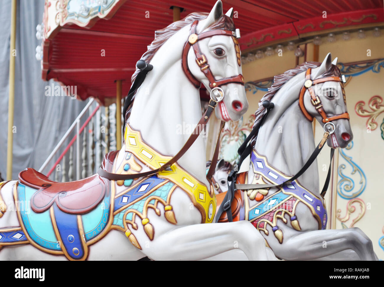 Schöne weisse Pferde Weihnachten Karussell in einem Ferienpark. Zwei Pferde auf einem traditionellen Jahrmarkt vintage Paris Karussell. Merry-go-round mit Pferden Stockfoto