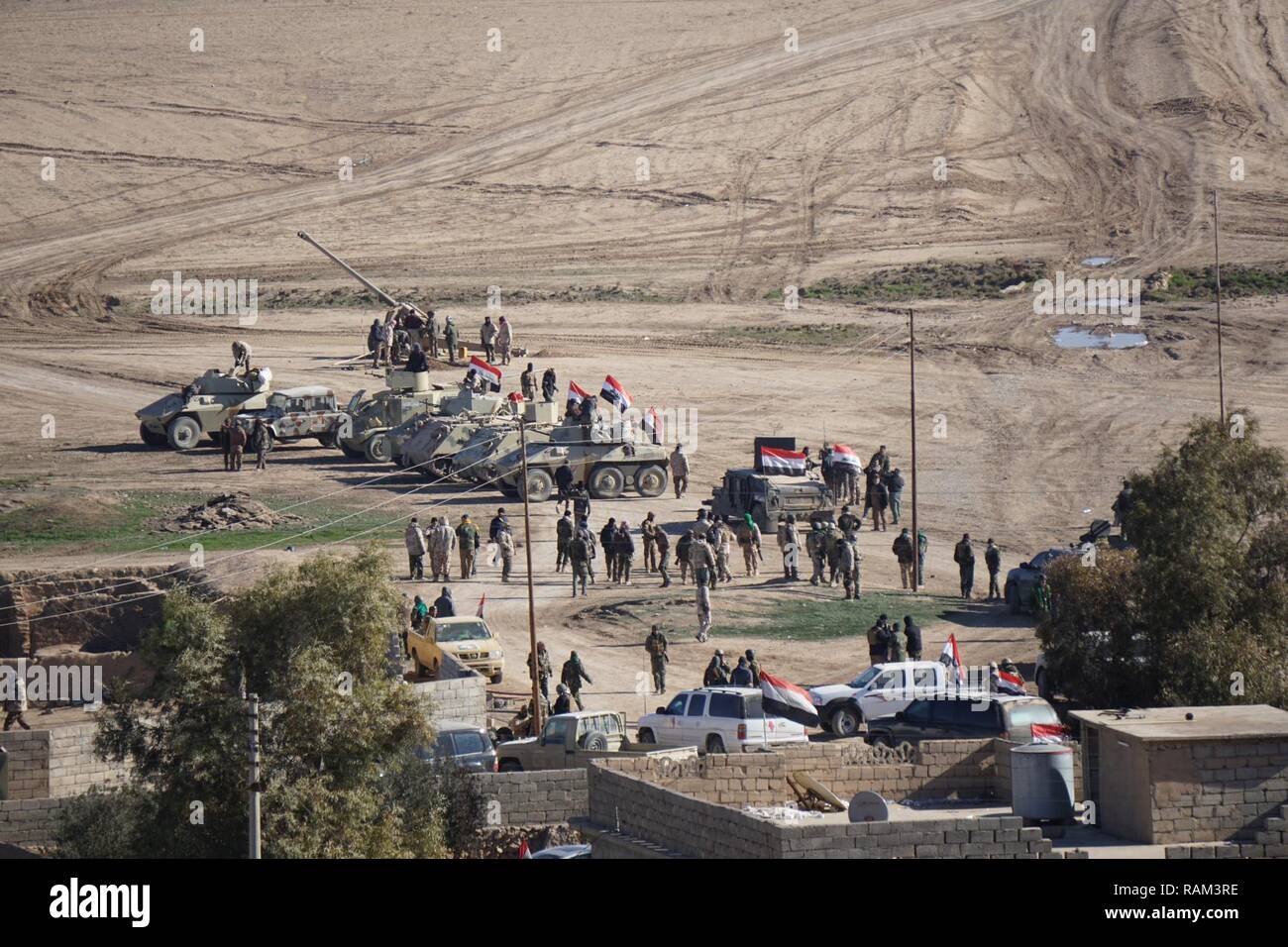 Schützenpanzer, eine artillerie Stück und Soldaten aus dem 9. irakischen Armee Division ihre Fahrzeuge während clearing Bakhaira Dorf und Umgebung am ersten Tag der Schlacht West Mosul, Jan. 19, 2017 zu befreien. 9 IAD ist mit beraten und unterstützen Teams 2 Bataillon partnered, 508Th Parachute Infantry Regiment, 2nd Brigade Combat Team, 82nd Airborne Division. 2 BCT, 82nd Abn. Div. ist zur Unterstützung der Operation inhärenten Lösung bereitgestellt, die irakischen Sicherheitskräfte, die Partner durch die Mission zu ermöglichen, zu beraten und zu unterstützen, einen Beitrag Planung, Intelligenz und eine Sammlung Stockfoto