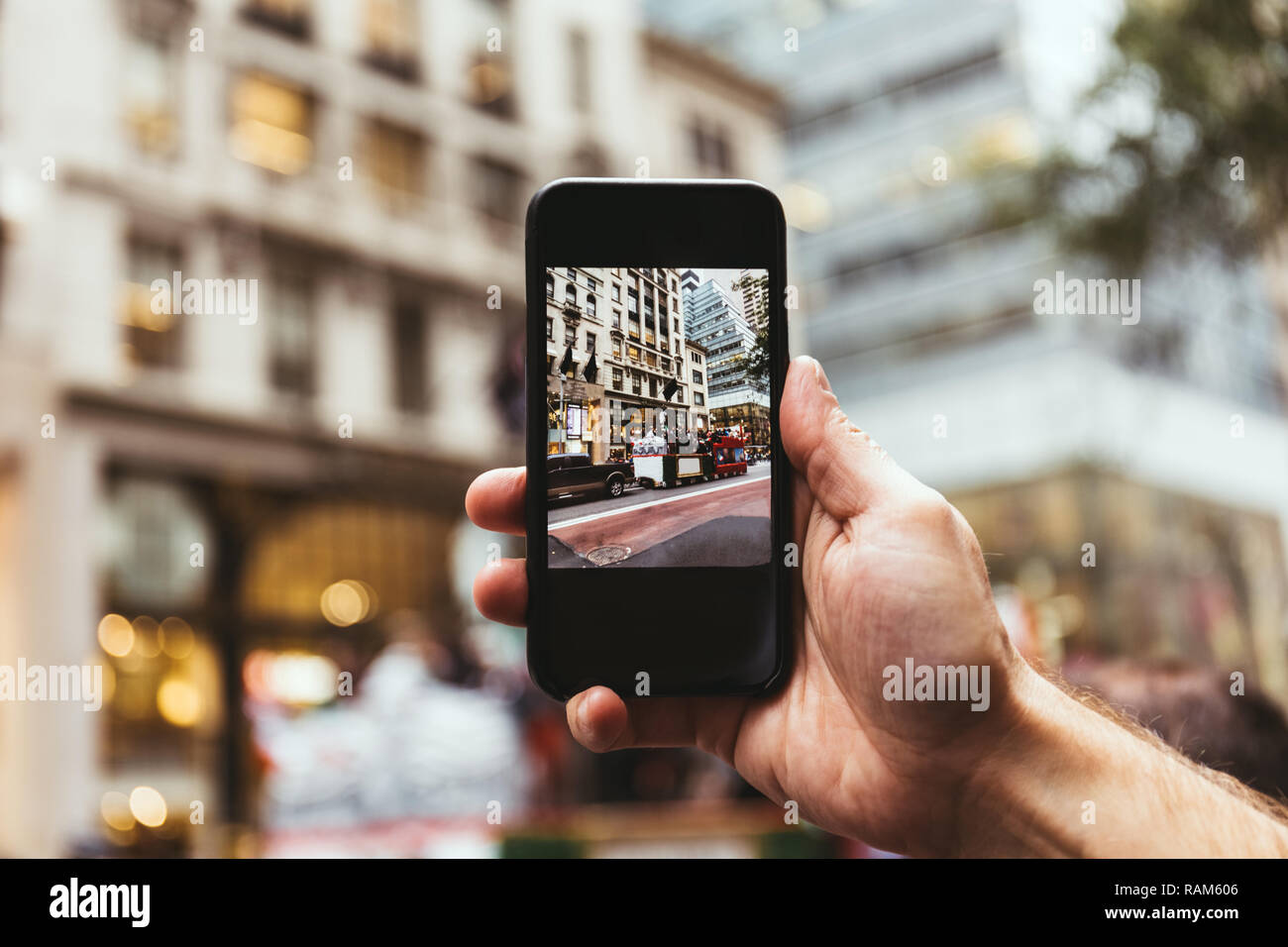 7/8 shot fo Mann mit Smartphone unter Bild von New York City Straße Stockfoto
