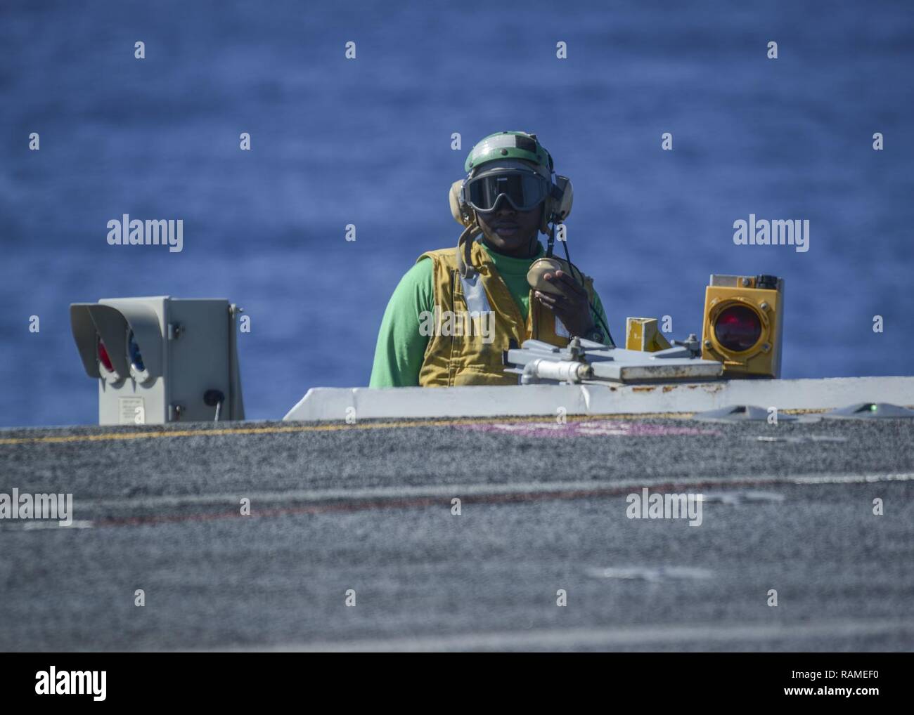 Pazifik (Feb. 20, 2017) - der Luftfahrt Bootsmann Mate (Ausrüstung) in der 2. Klasse Terrance Rayford, ein Eingeborener von Little Rock, Ak., wirkt als Deck während der Flugbetrieb auf dem Flugzeugträger USS Nimitz (CVN 68). Der Nimitz wird derzeit die Durchführung Flotte Austausch Squadron Carrier Qualifikationen. Stockfoto