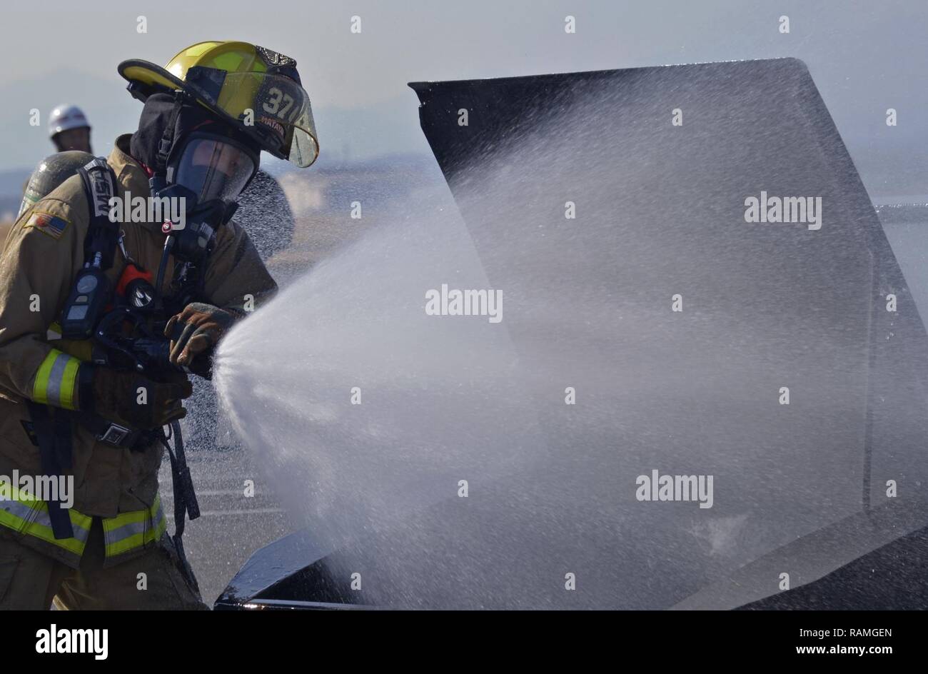 Takuto Hatayama, 374 Bauingenieur Squadron Feuerwehr fire fighter, stellt ein Brand während eines Fahrzeugs Fire Training Szenario Yokota Air Base, Japan, Jan. 16, 2017. Yokota's Personal mit der Japan Verteidigung-kraft und Fussa Feuerwehren ausgebildet unterschiedliche Perspektiven auf das Fahrzeug, um Brände zu gewinnen. Stockfoto