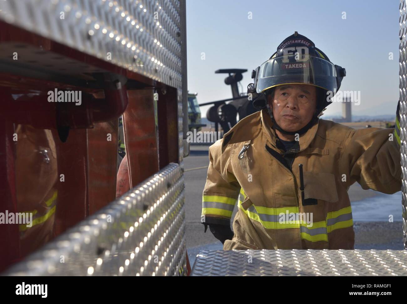 Nobuhito Takeda, 374 Bauingenieur Squadron Feuerwehr fire fighter, klettert ein Feuerwehrauto zu helfen, einen Schlauch vor Abschluss eines Fahrzeugs Fire Training Szenario Yokota Air Base, Japan, Feb.16, 2017 entladen. Yokota's Personal mit der Japan Verteidigung-kraft und Fussa Feuerwehren ausgebildet unterschiedliche Perspektiven auf das Fahrzeug, um Brände zu gewinnen. Stockfoto