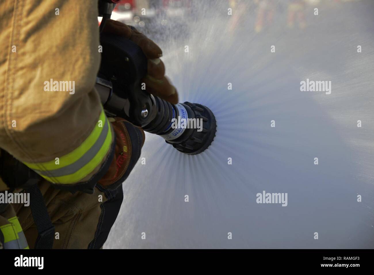 Senior Airman Jordanien Spiceland, 374 Bauingenieur Squadron Feuerwehr fire fighter, führt einen Test auf einem Schlauch ausführen, bevor Sie ein Fahrzeug Fire Training Szenario Yokota Air Base, Japan, Jan. 16, 2017. Bei diesem Szenario, Spiceland war Teil des Stand-by-Team bietet eine Safety Line die primäre Teams im Notfall zu helfen. Stockfoto